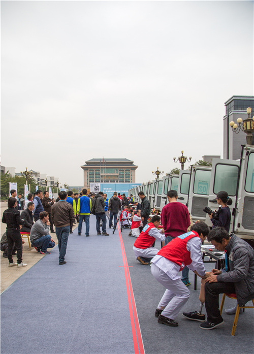 图为竞赛选手组装假肢和患者试穿