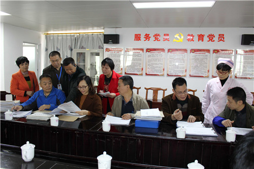 图为督导组专家在北流市人民医院检查残疾预防创建试点工作档案资料